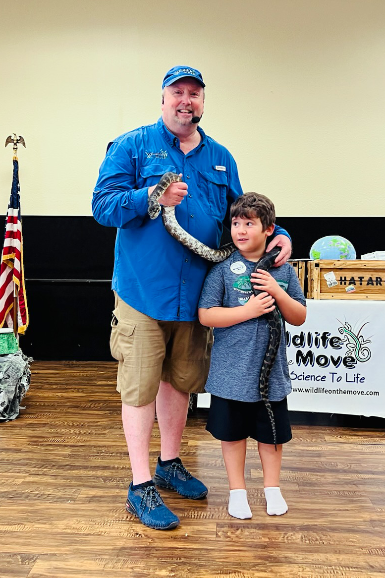 Man and boy holding a snake