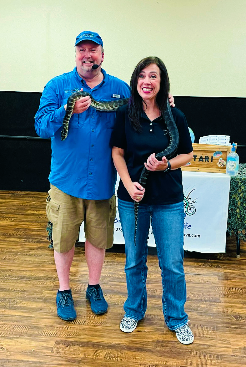 Presenter and woman with snake around her neck
